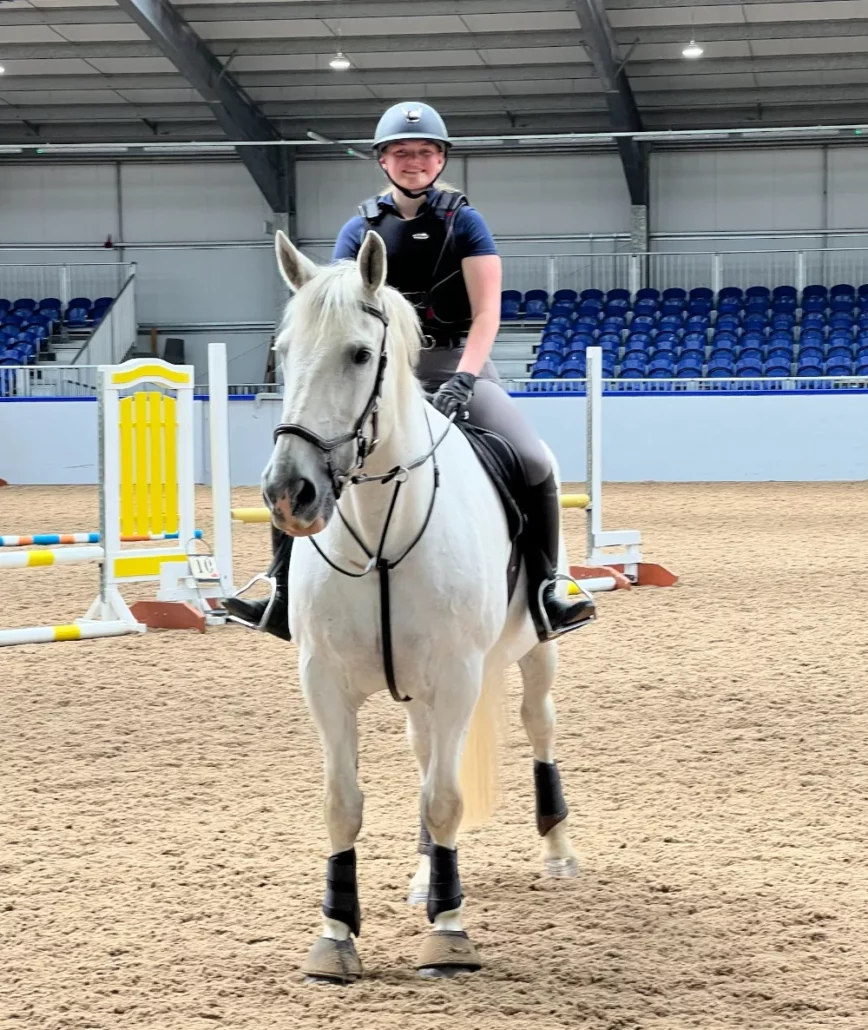 Equine study abroad student riding white horse in scotland