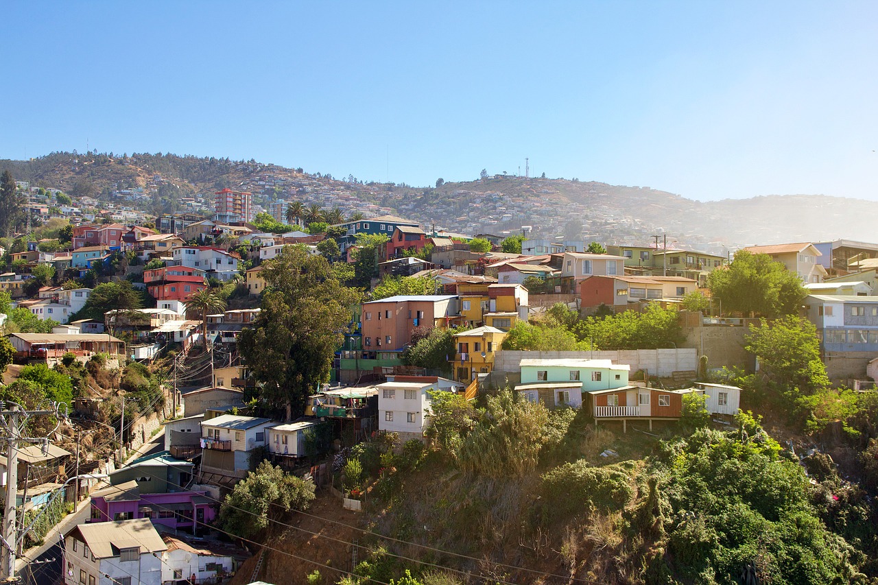 Colorful hillside houses in Valparaíso under clear blue sky.