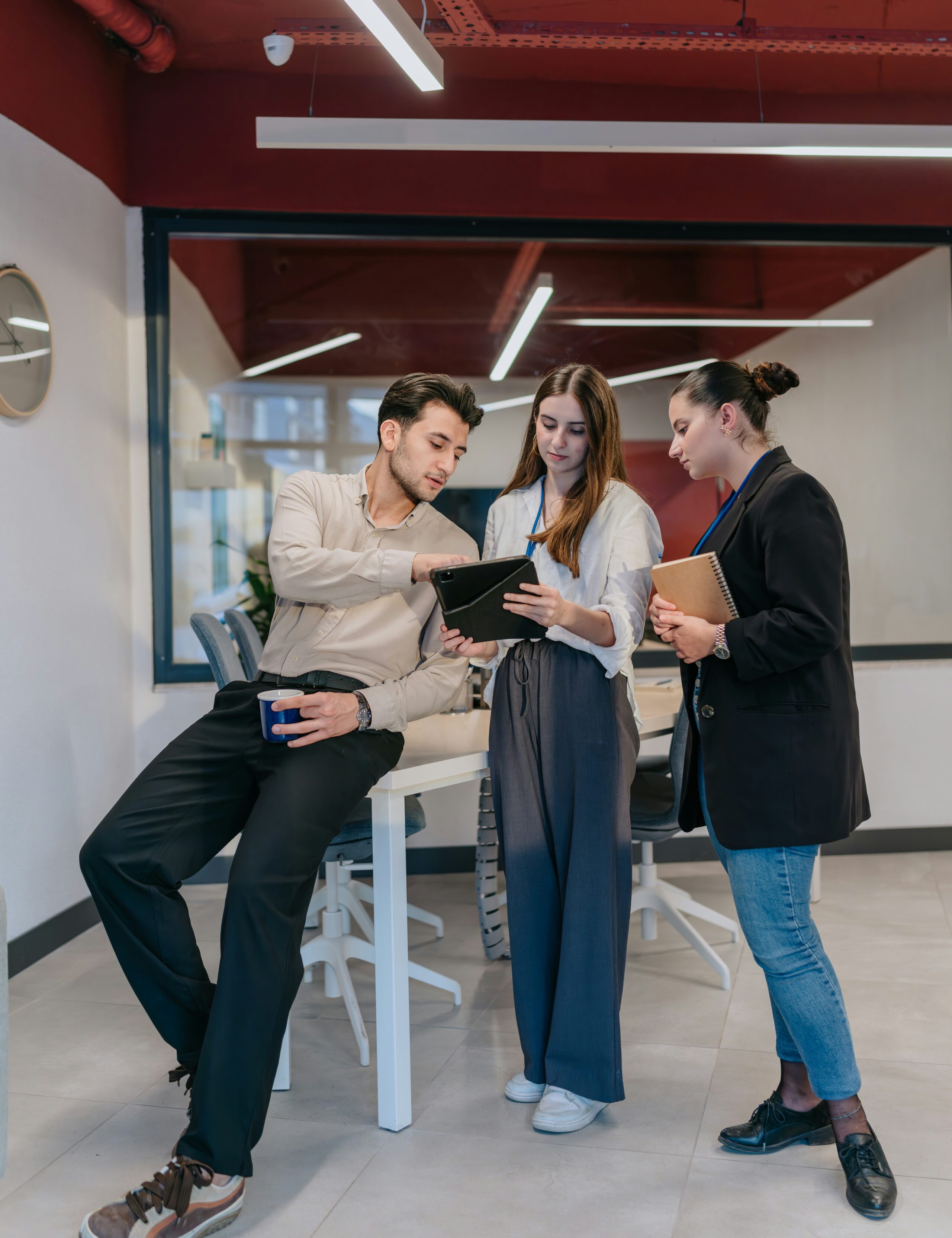 Three coworkers discussing work while looking at a tablet.