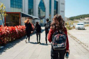 Female student with backpack walking toward university campus