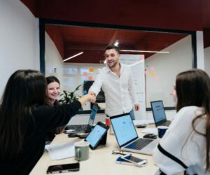 Team members shaking hands during a collaborative office meeting