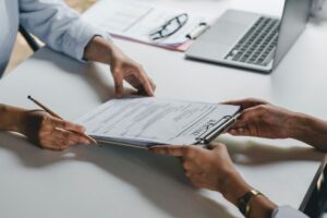 Job candidate handing a resume to an employer during an interview