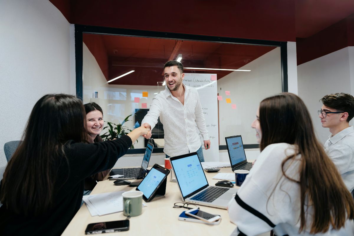 Team members shaking hands during a collaborative office meeting