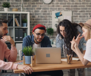 Young marketing interns working together on a laptop in an office