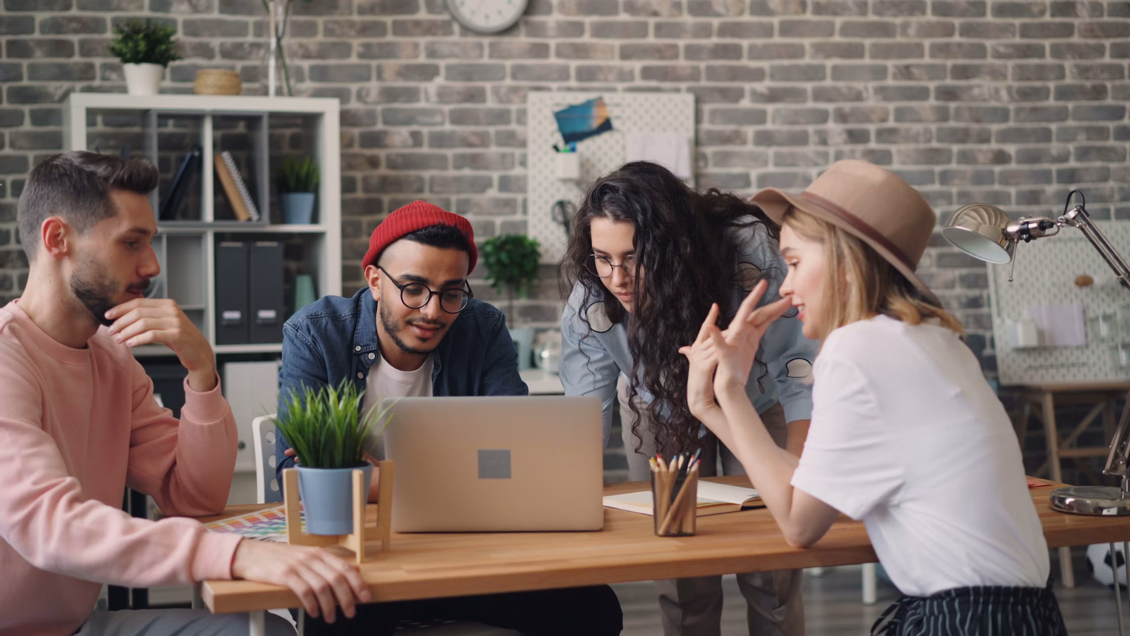 Young marketing interns working together on a laptop in an office
