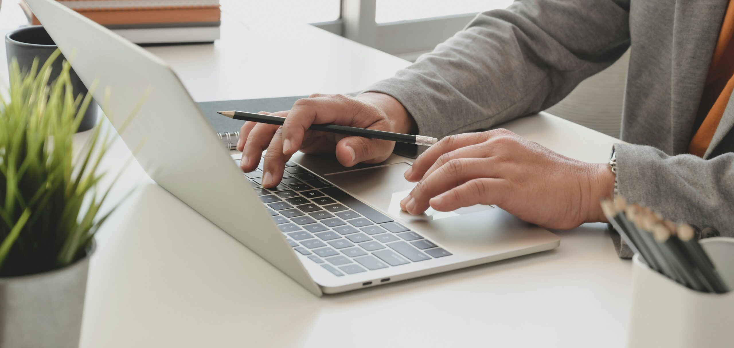 Student writing a cover letter for an internship on a laptop at a desk