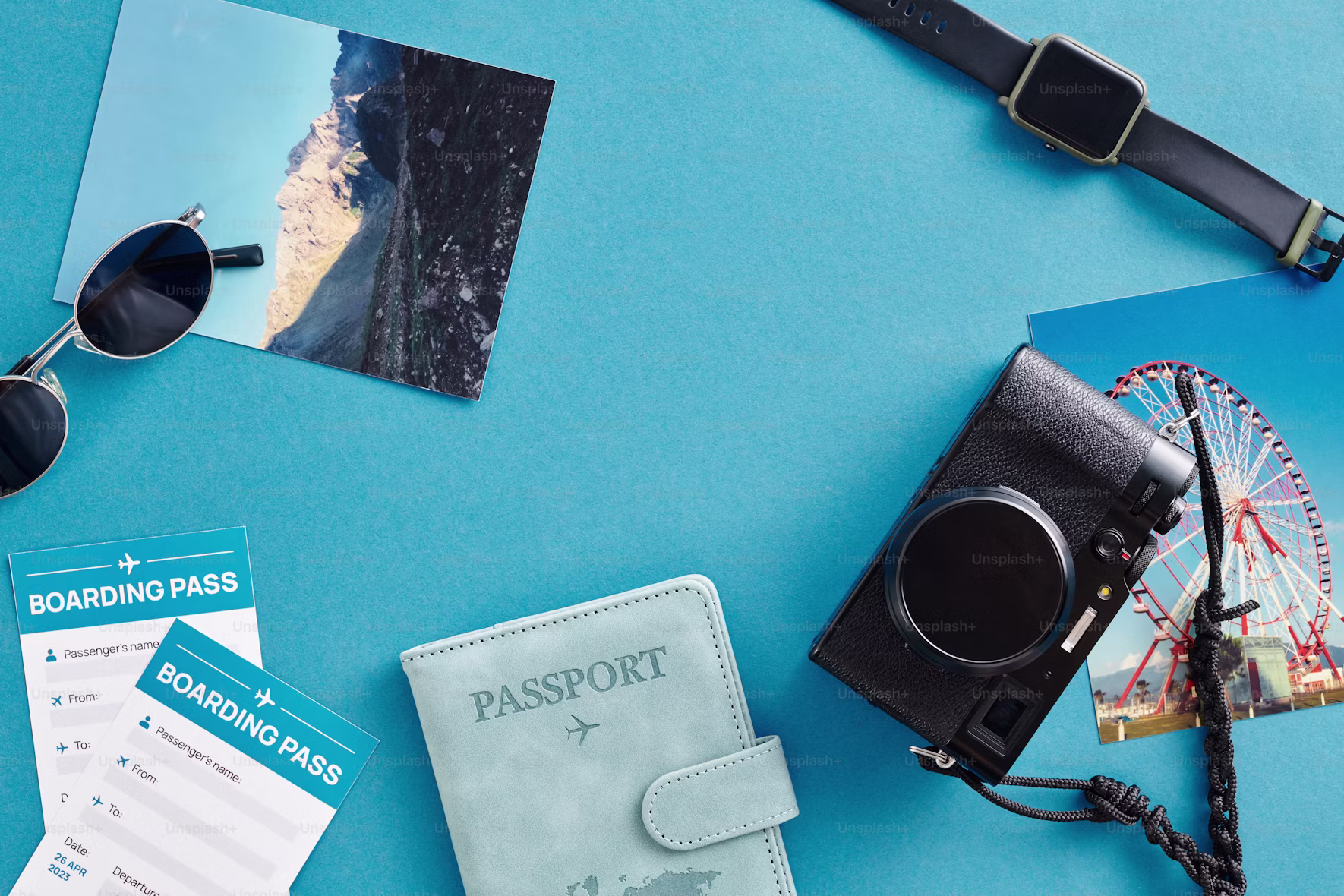 Travel flat lay with passport, boarding passes, camera, and sunglasses on a blue background.