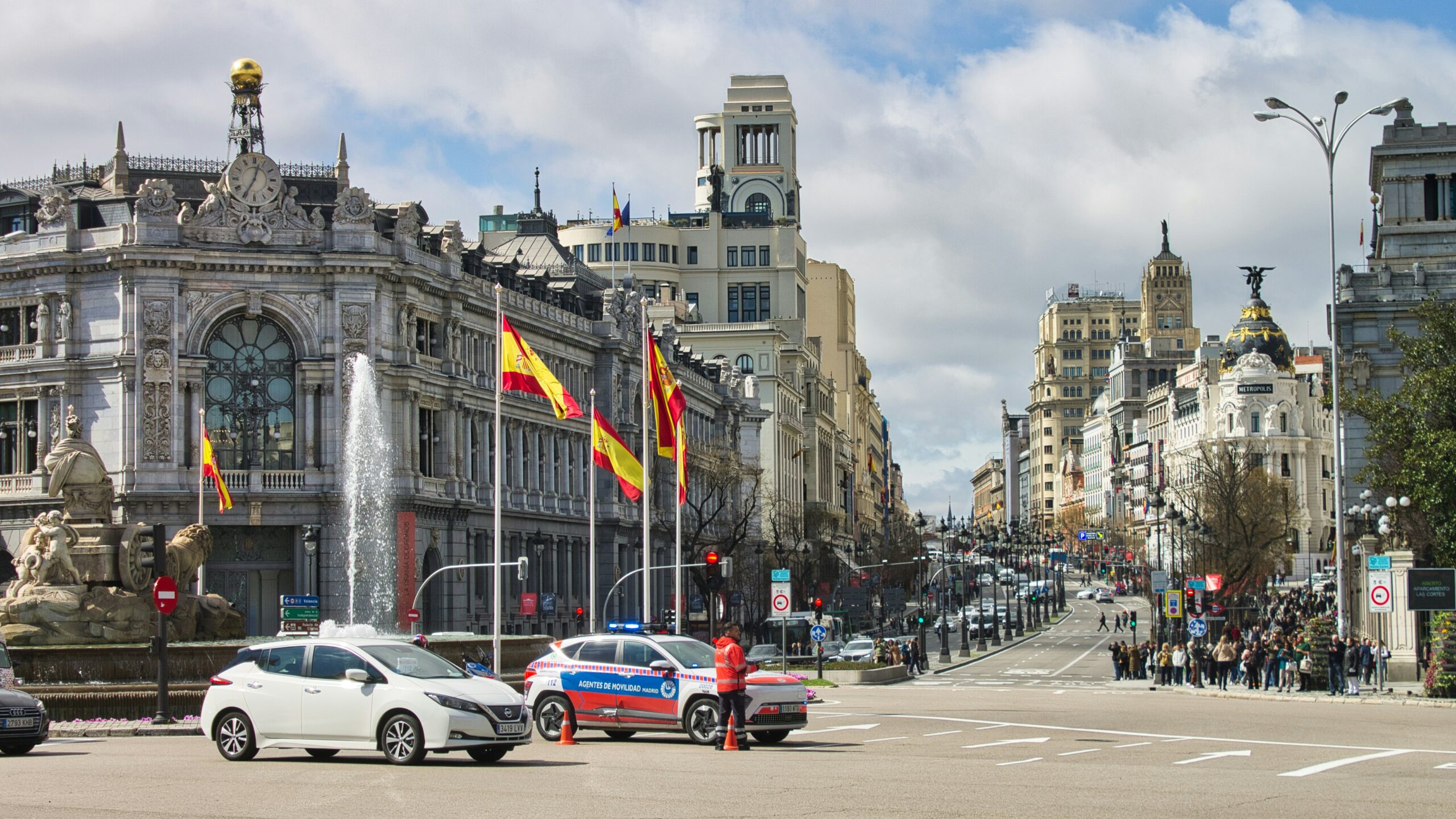 Street view of historic Madrid architecture and Spanish flags
